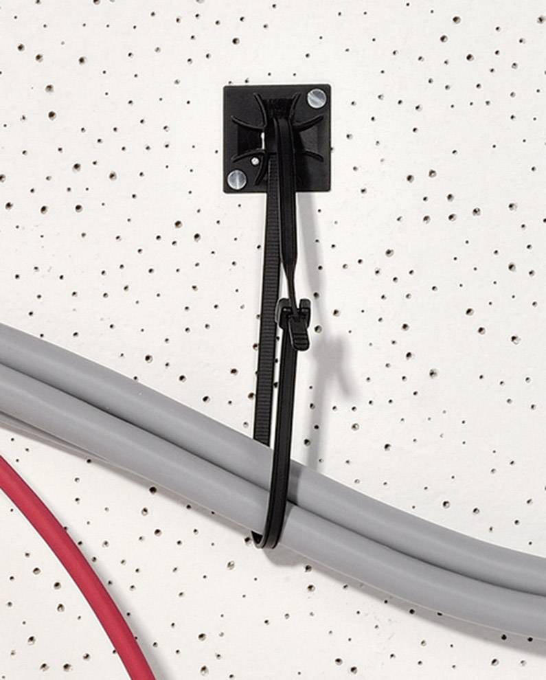 Un serre-câble noir fixe un câble gris sur un mur perforé. Un câble rouge passe en arc sur le côté.