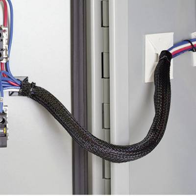 Un conduit tressé guide en toute sécurité un faisceau de câbles à travers une ouverture de machine pour établir une connexion avec des dispositifs de commutation.