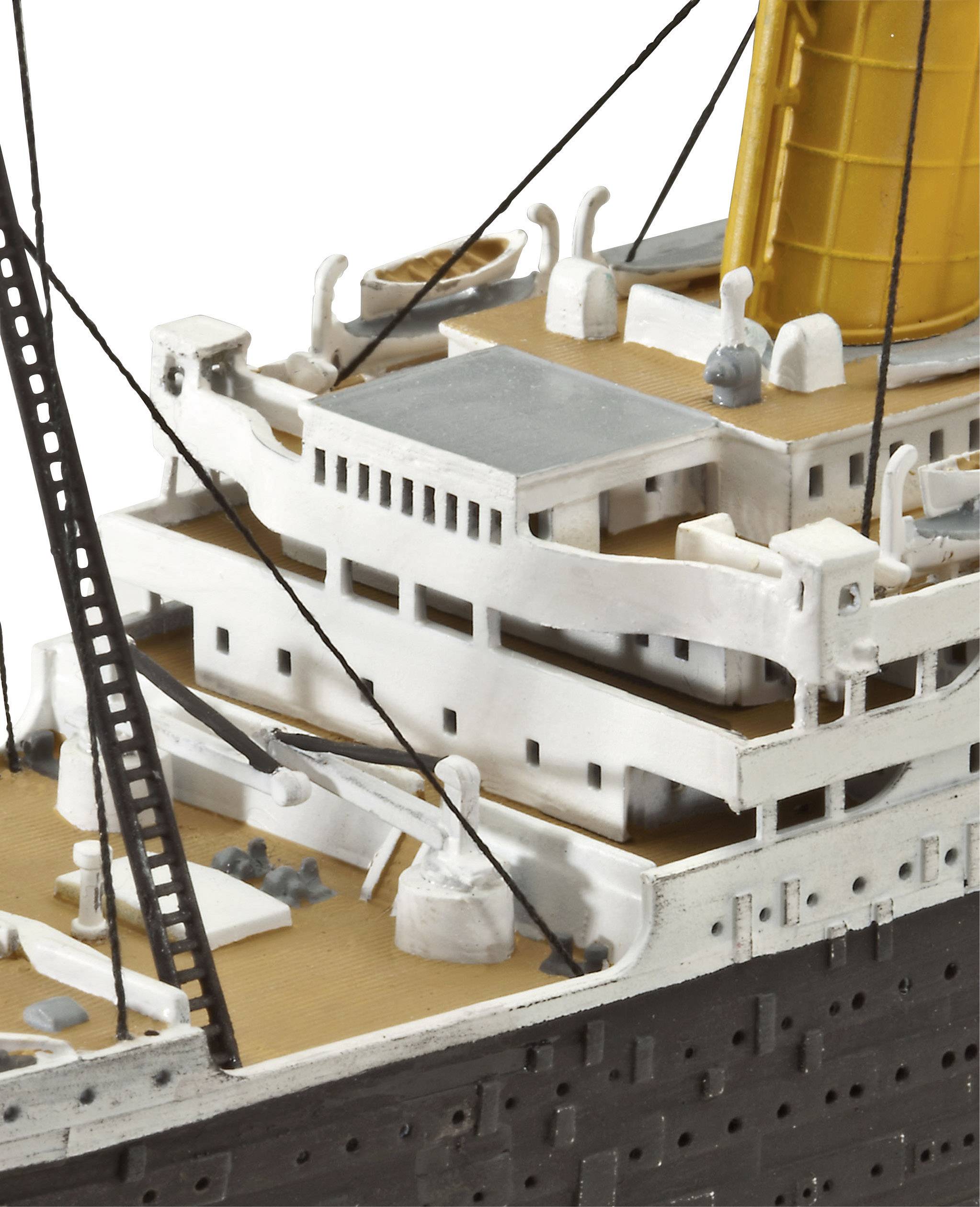 Gros plan détaillé d'une maquette de navire avec une cheminée jaune et des superstructures blanches. Le focus est mis sur trois ponts.