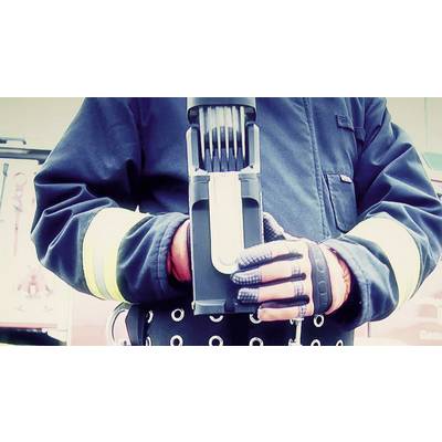 Une personne portant un équipement de protection tient un appareil avec plusieurs câbles ou antennes sombres, probablement en lien avec des travaux de pompiers.