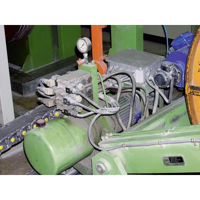 Installation industrielle avec une pompe hydraulique verte, plusieurs tuyaux et un manomètre.