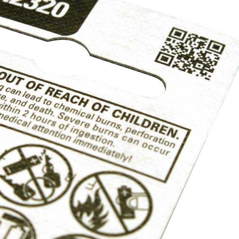 Avertissement sur l'emballage : 'Tenir hors de portée des enfants. Peut causer des brûlures chimiques.' Des pictogrammes indiquent les dangers.