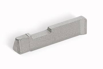 Un morceau de métal gris rectangulaire aux bords biseautés, probablement une pièce de machine ou un composant d'outil.