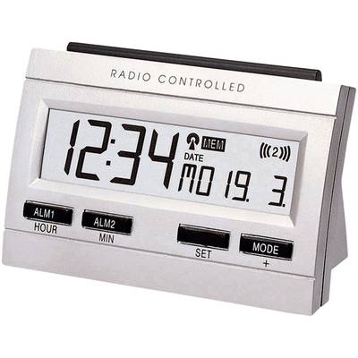 Horloge numérique affichant '12:34' et la date 'LUN 19. 3.', fonctionnant sur pile et radio-pilotée, avec touches pour l'alarme et les réglages.