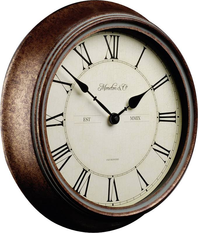 Horloge murale ronde avec des chiffres romains et un cadre en métal, indiquant environ 10 h 10.