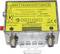 Un boîtier métallique avec une étiquette jaune présente un amplificateur large bande. Plage de fréquence : 5-1000 MHz. Gain : 33 dB. Connexions : Entrée, Sortie.