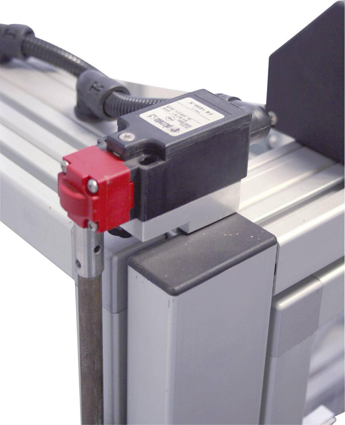 Un interrupteur de proximité dans un cadre rectangulaire argenté, fixé avec un boîtier rouge et noir, câblé pour des applications industrielles.