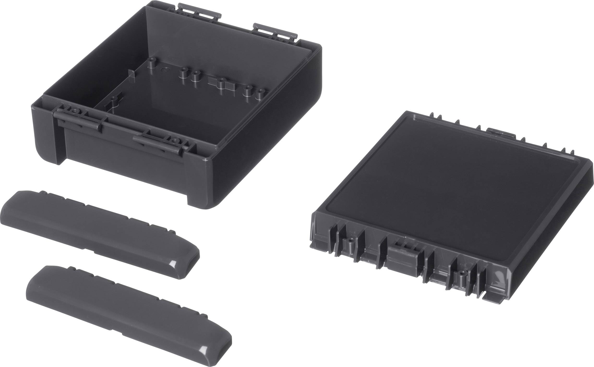 Des pièces en plastique noir rectangulaires, composées d'une base plate, d'un couvercle et de deux habillages latéraux. Elles sont disposées côte à côte.