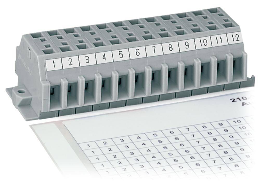 Barrette de connexion numérotée de 1 à 12, pour l'organisation des connexions électriques, à côté d'un schéma étiqueté sur papier.