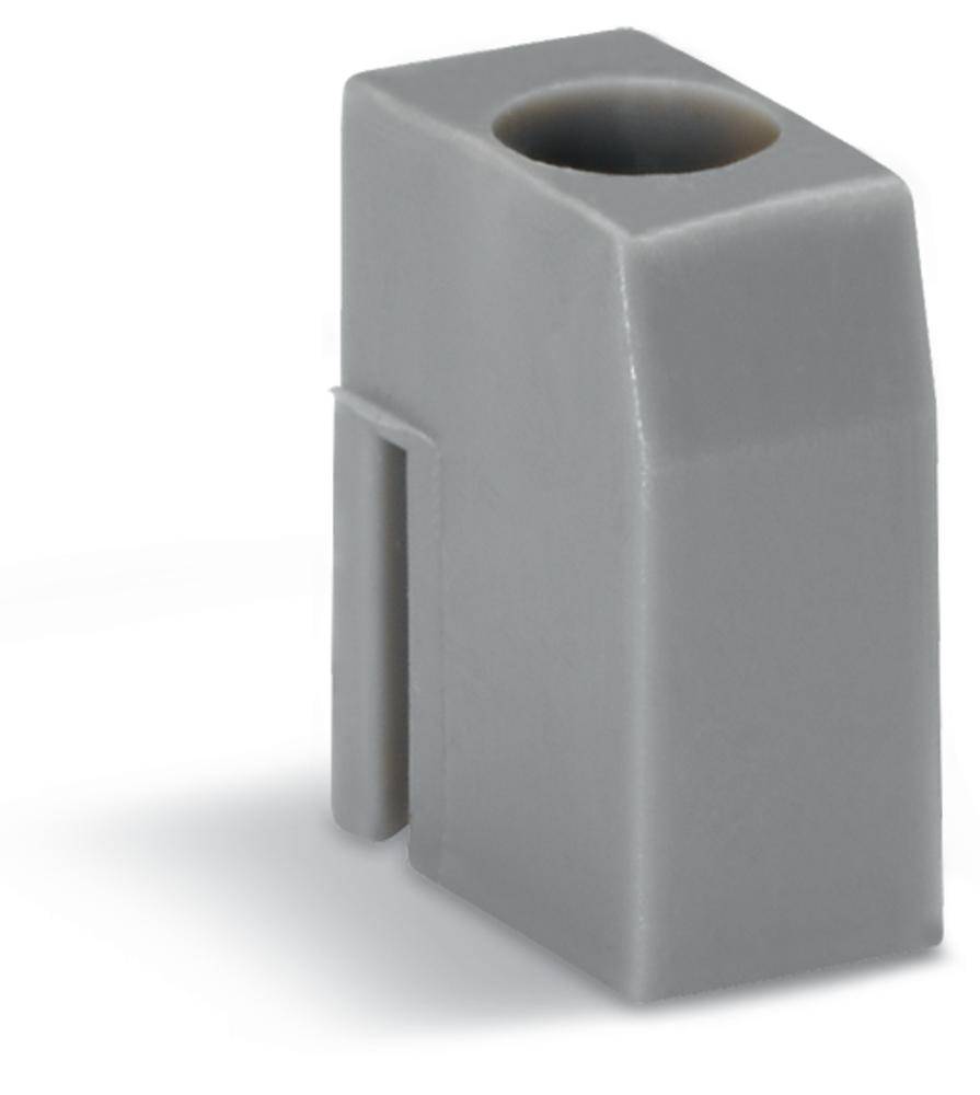 Pièce rectangulaire grise en plastique avec une ouverture ronde en haut, probablement un élément de connexion technique.