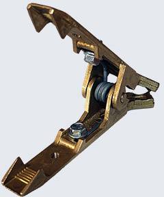 Support de pince métallique marron avec mécanisme à ressort, partiellement ouvert. Utilisé pour maintenir ou fixer des objets.