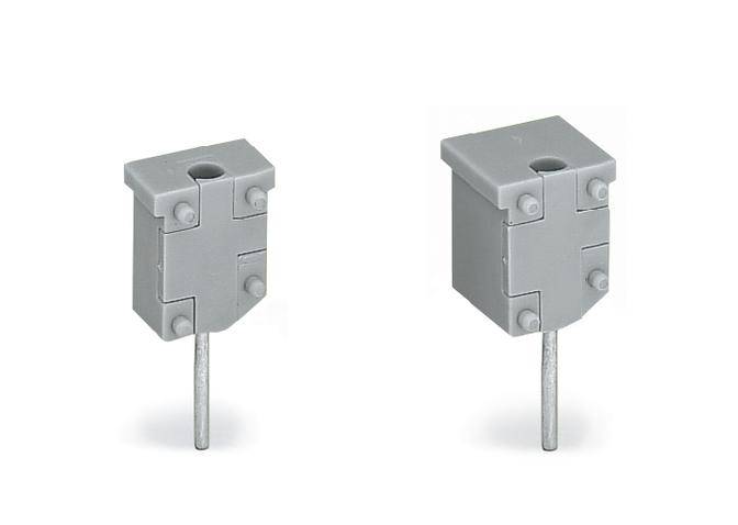 Deux connecteurs électriques rectangulaires gris avec des broches métalliques en bas, côte à côte sur un fond blanc.