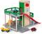 Garage à jouets en bois à deux niveaux, avec un ascenseur rouge, un toboggan et de petites voitures. Un panneau 'P' indique le parking.