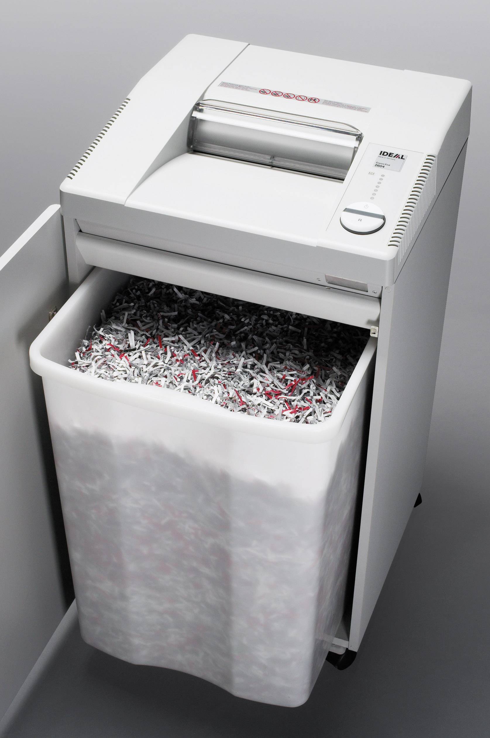 Destructeur de documents avec son bac ouvert, rempli de documents déchiquetés.