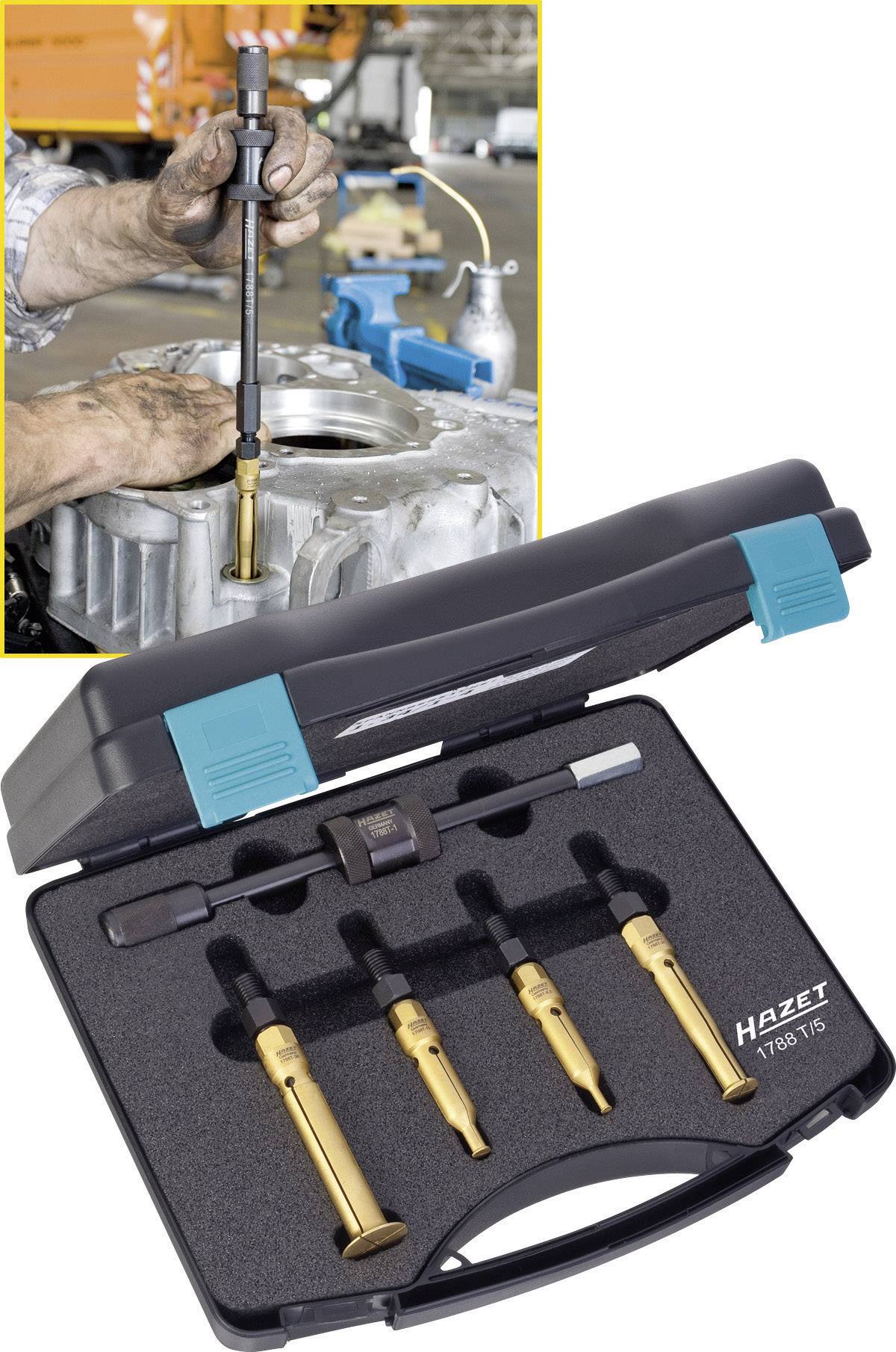 L'image montre un ensemble d'outils HAZET dans un coffret ouvert, comprenant plusieurs pièces rapportées dorées. En arrière-plan, un outil est utilisé pour travailler sur une grande pièce métallique.