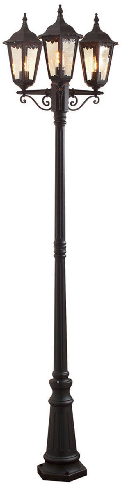 Un lampadaire décoratif à trois lampes de style traditionnel. Métal sombre avec des ornements filigranés.