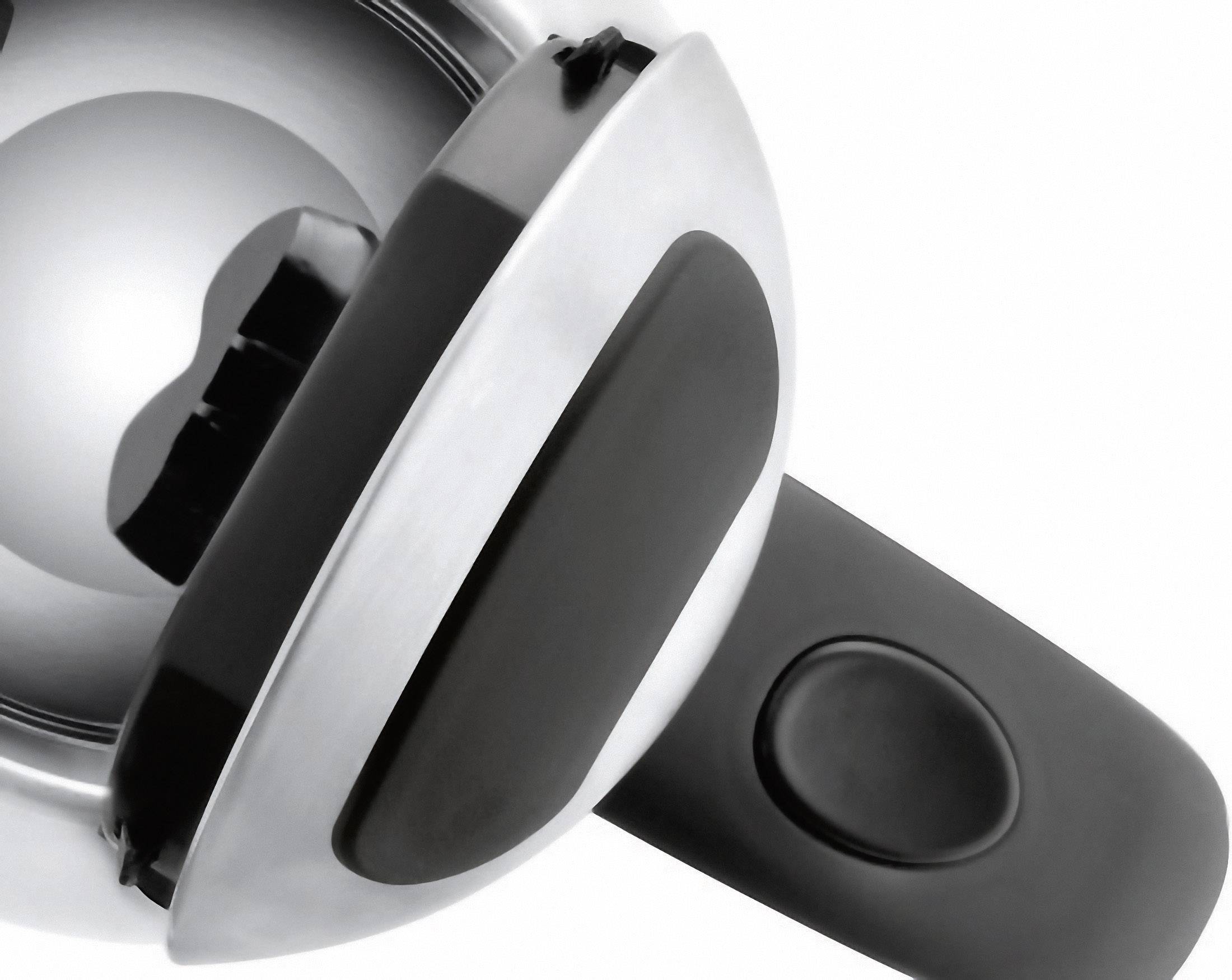 Un appareil de cuisine chromé avec une lame tranchante, probablement un coupe-pommes, est posé sur une surface blanche.