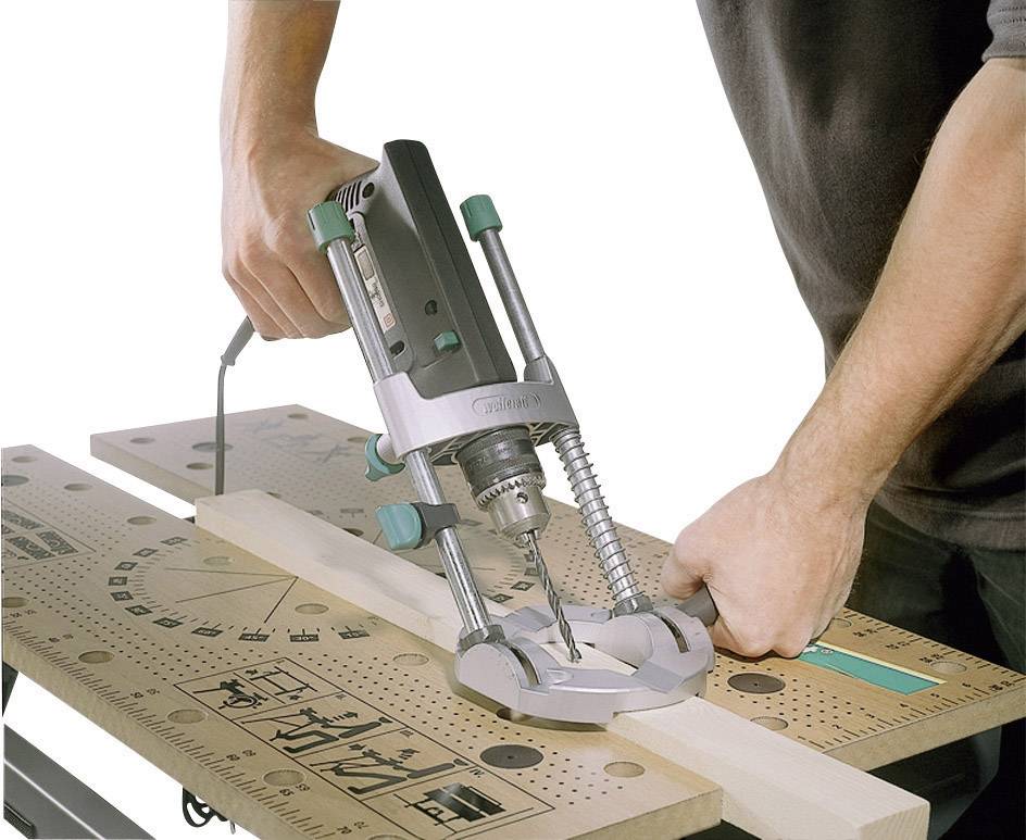 Une personne utilise une défonceuse électrique sur une planche de bois posée sur un établi. L'outil travaille le bois avec précision.