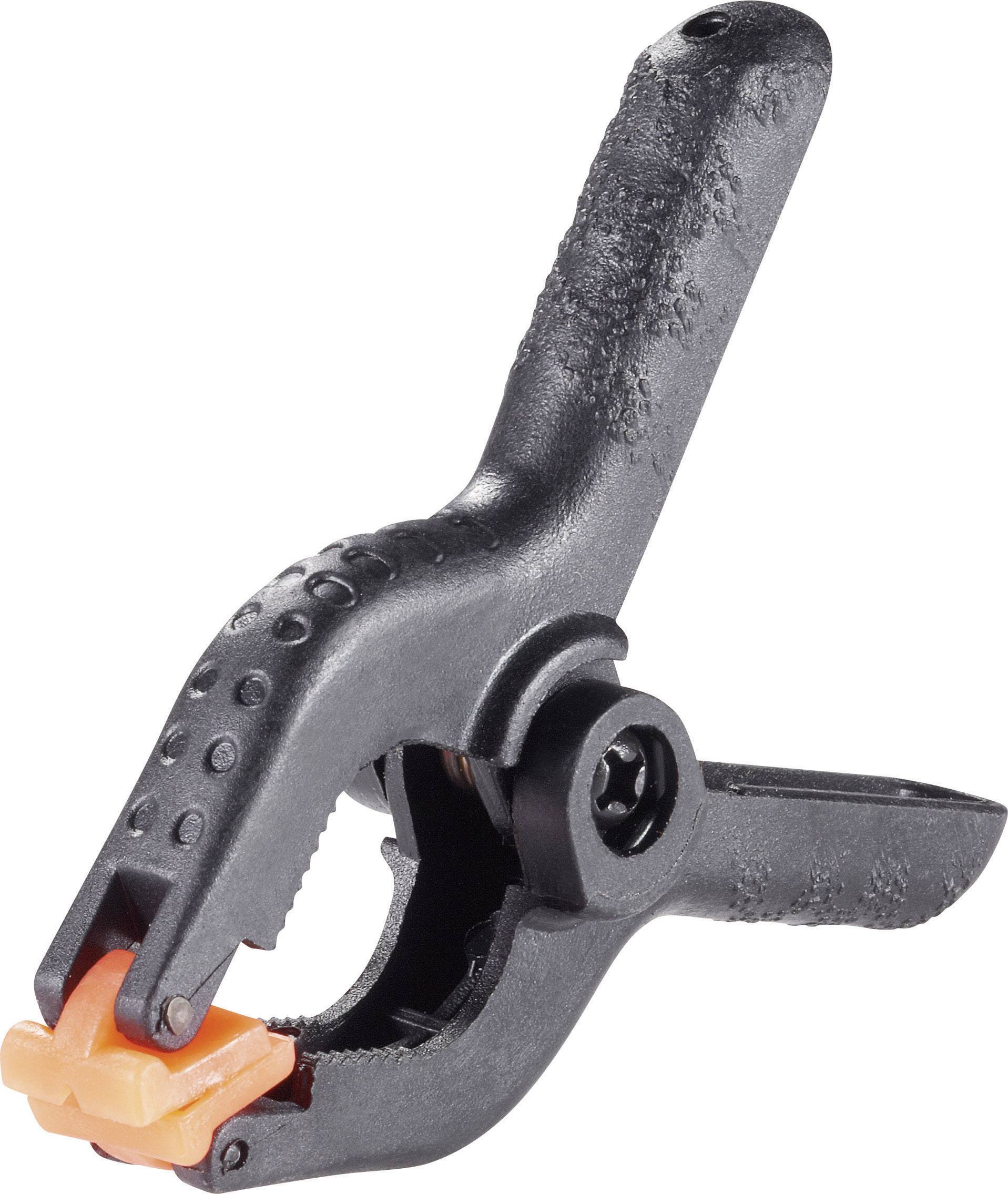 Pince à ressort noire avec embouts oranges, en plastique, outil typique d'atelier ou de bricolage servant à maintenir des matériaux en place.