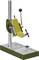 Support de perceuse en métal avec levier manuel et tête de perçage rotative sur une base stable. Adapté pour des travaux de perçage précis.