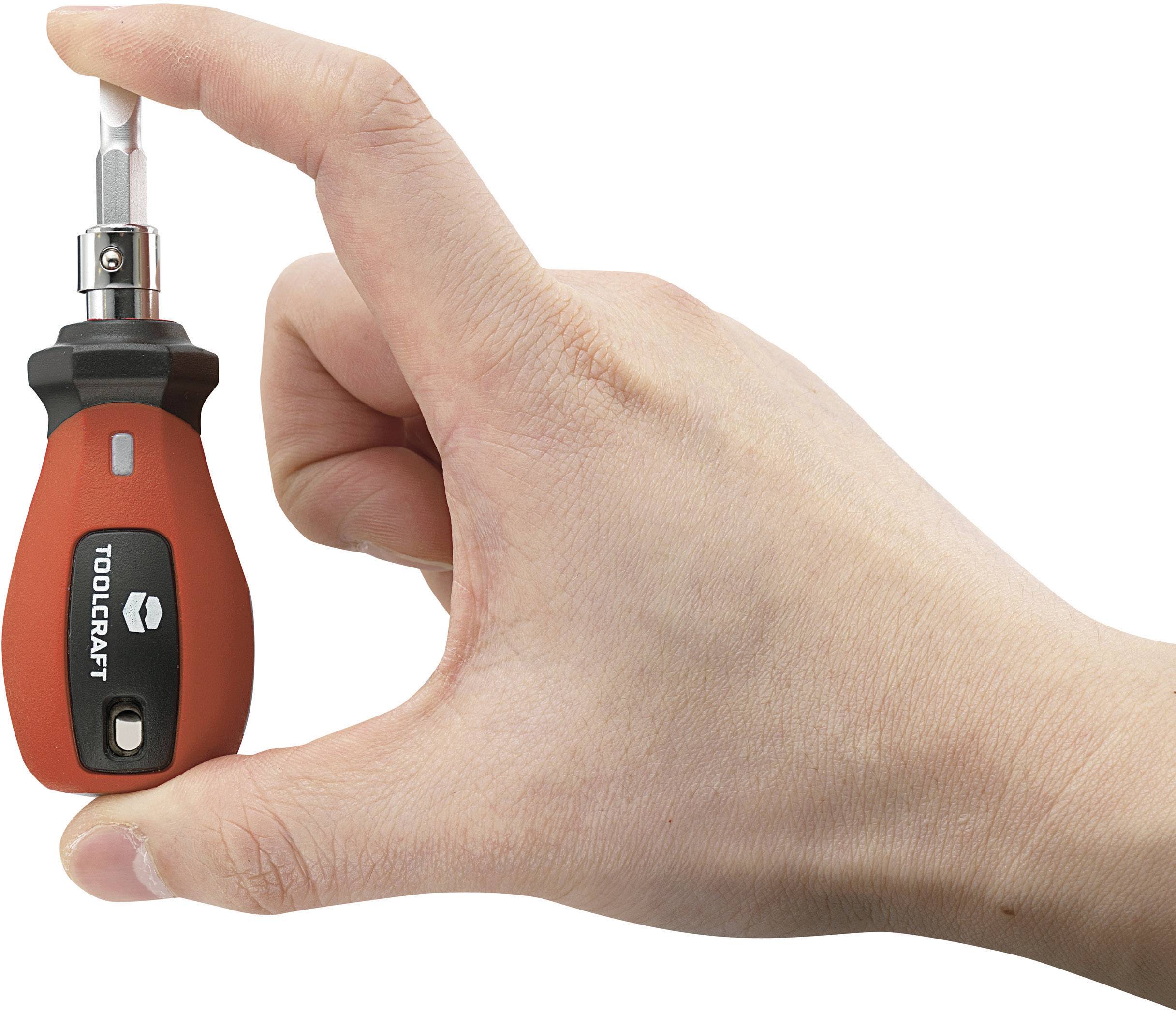 Une main tient un petit tournevis rouge TOOLCRAFT avec embout interchangeable entre le pouce et l'index.