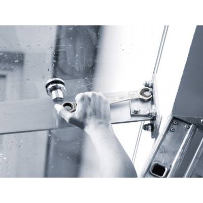 Une main utilisant une clé à molette pour ajuster une porte en verre, probablement lors d'une installation ou d'une réparation.