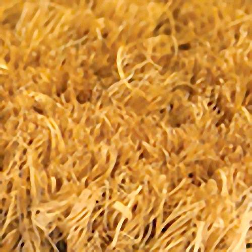 Gros plan sur une surface dense et structurée d'un tapis d'herbe dorée ou de fibres de coco, qui paraît vivante et authentique.