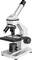 Microscope argenté avec trois objectifs, une platine ajustable et une grande molette de mise au point, en vue latérale.