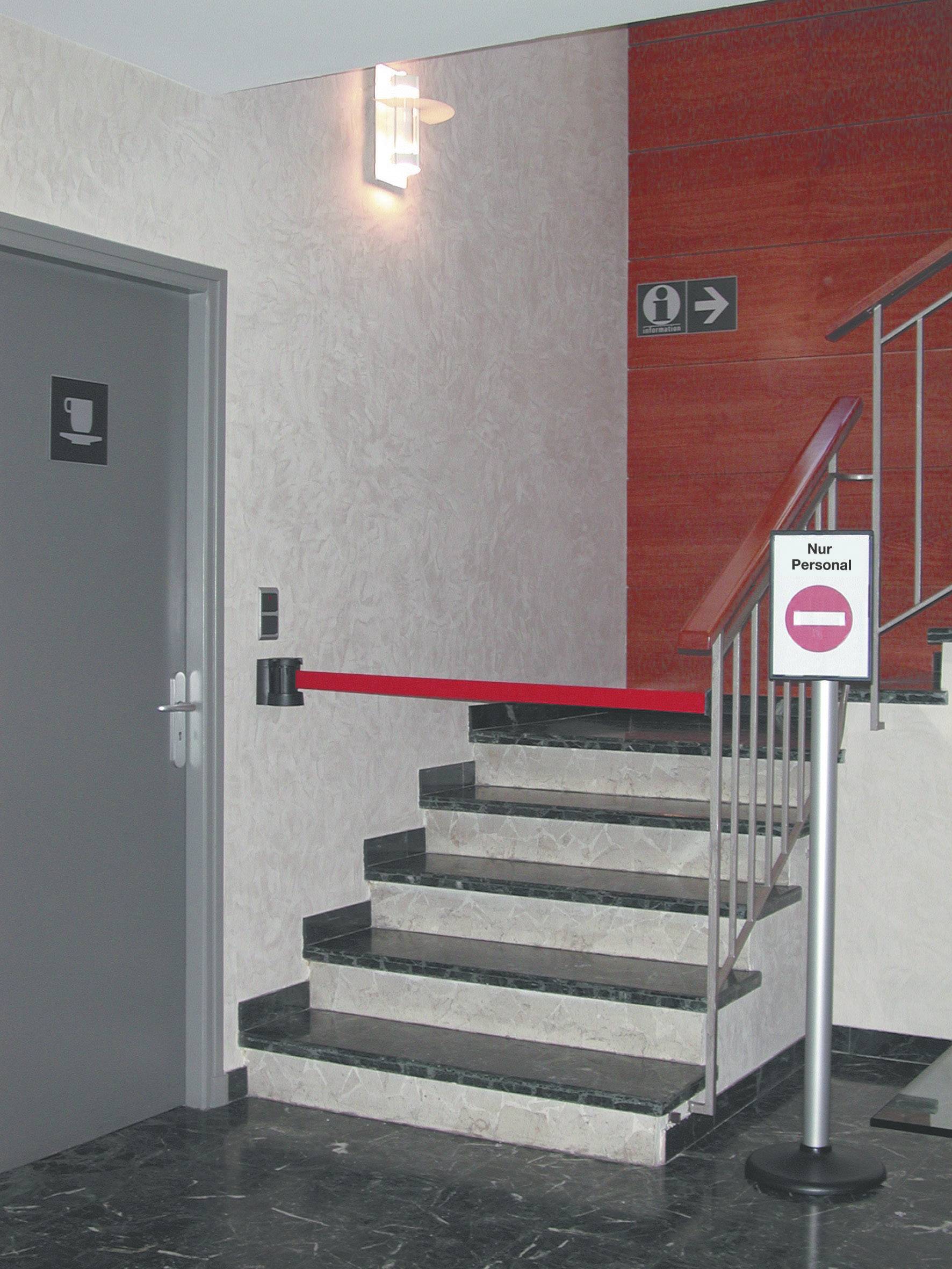 Un escalier est bloqué par un ruban rouge et blanc. Un panneau à côté indique « Personnel autorisé uniquement ». À gauche se trouve une porte de toilettes.