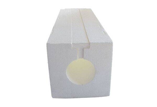 Un bloc creux rectangulaire blanc en polystyrène, avec une découpe circulaire au centre, souvent utilisé à des fins d'isolation.