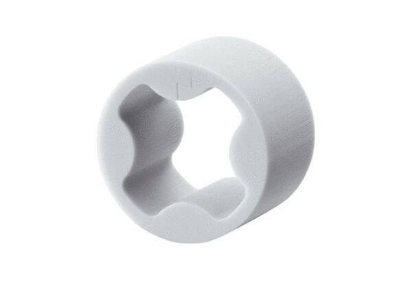 Un adaptateur cylindrique blanc en plastique avec un motif en étoile intérieur, probablement un élément d'un système de fermeture.