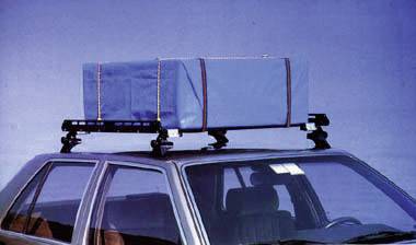 Une voiture avec un porte-bagages bleu sur le toit, fixé avec des sangles. Le véhicule est stationné devant un fond bleu.