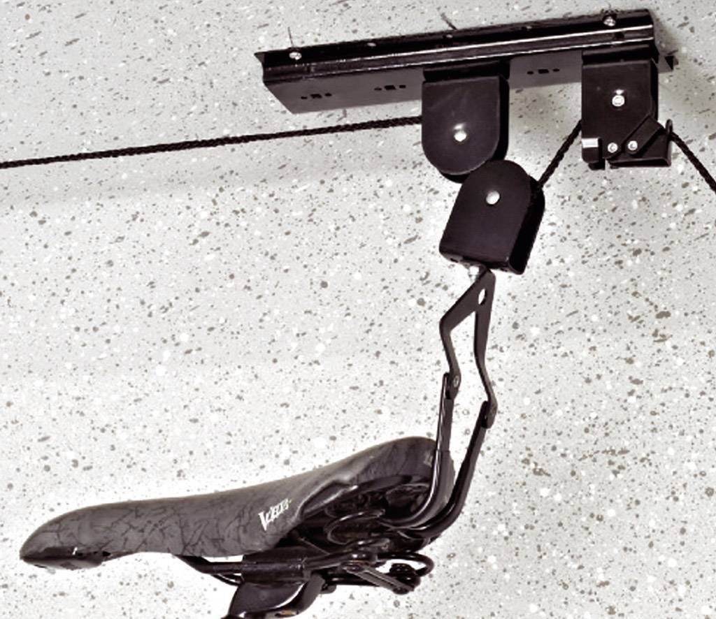 Selle de vélo monté sur un support de plafond qui permet de suspendre le vélo de manière économe en espace.