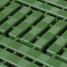 Revêtement de sol vert à lamelles parallèles, offrant une surface antidérapante, souvent utilisé dans les usines ou les ateliers.