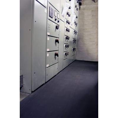 Rangée de panneaux de commande gris dans une salle technique. Plusieurs interrupteurs à bascule sont visibles. Le sol est recouvert d'un tapis noir.