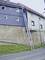 'Une échelle prolongeable monte le long d'un mur abrupt de maison.'