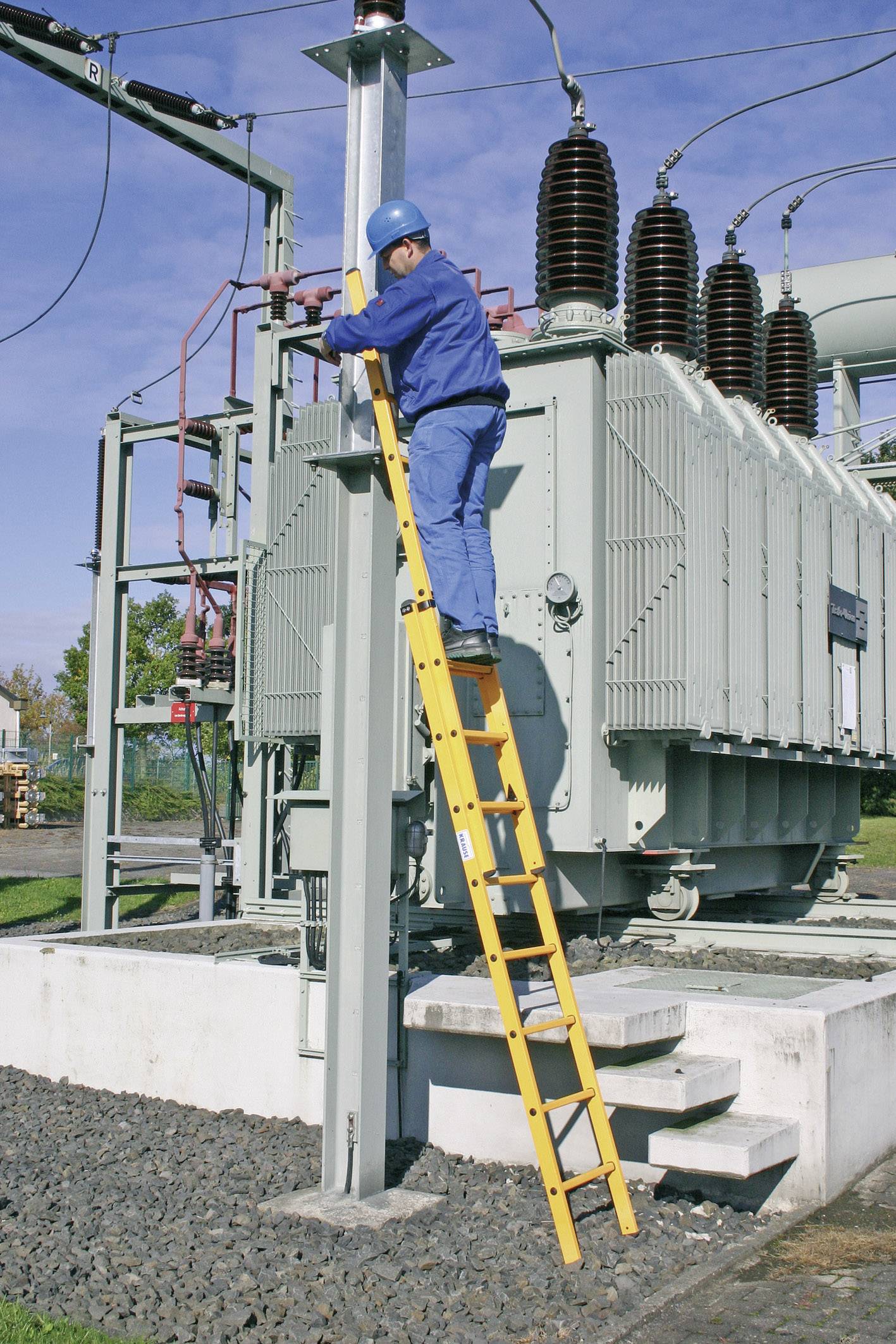 Un travailleur en tenue de protection est debout sur une échelle et effectue des travaux de maintenance sur un transformateur.