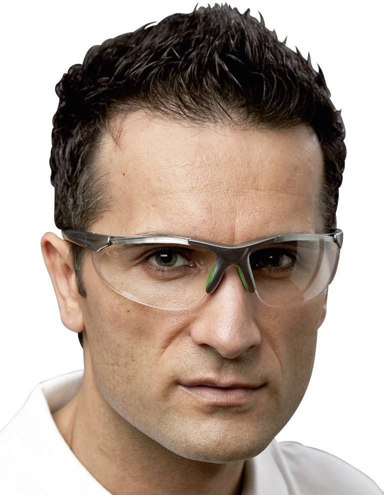 Un homme porte des lunettes de protection. Il a les cheveux courts et foncés et regarde directement l'objectif. Les lunettes ont des verres transparents et une monture noire.