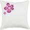 Housse de coussin blanche avec deux fleurs roses en haut à gauche, une grande et une plus petite, sur un fond uni.