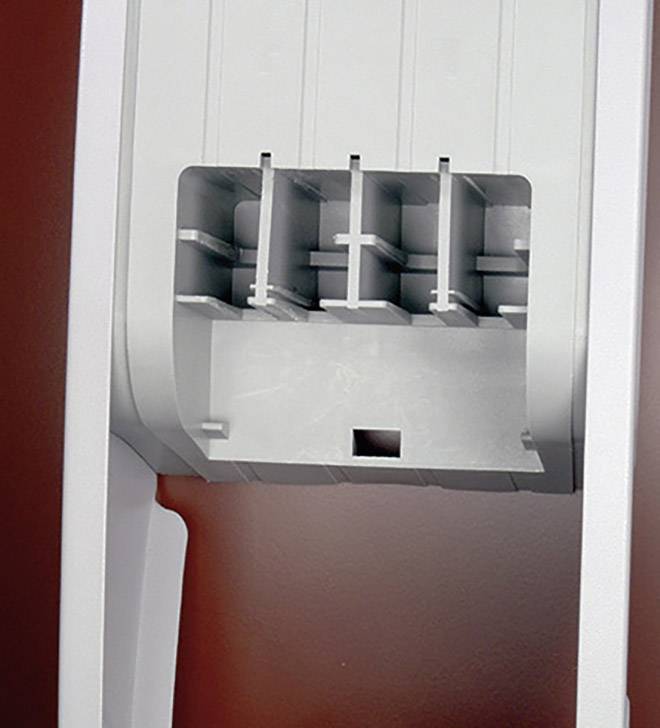 Un boîtier en plastique blanc avec plusieurs fentes verticales et un trou carré, sur un fond rouge.