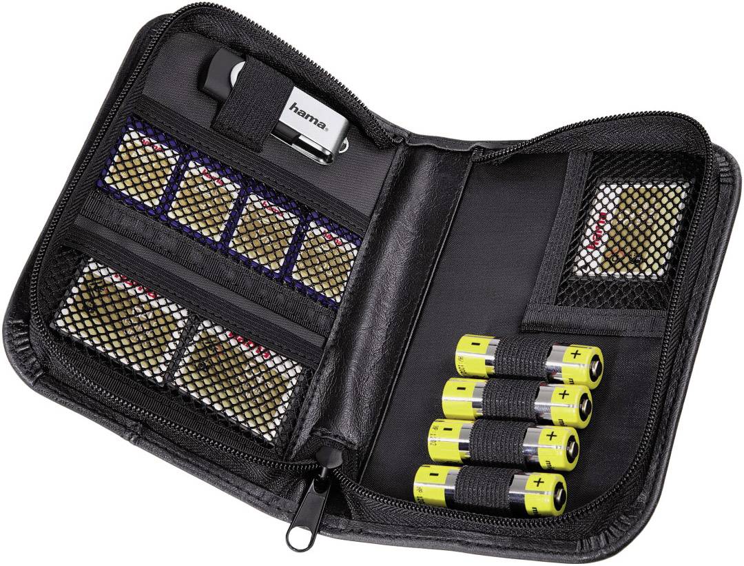 Sac noir ouvert contenant des cartes mémoire et des batteries dans des pochettes en filet. Un clé USB argentée est située en haut à gauche.