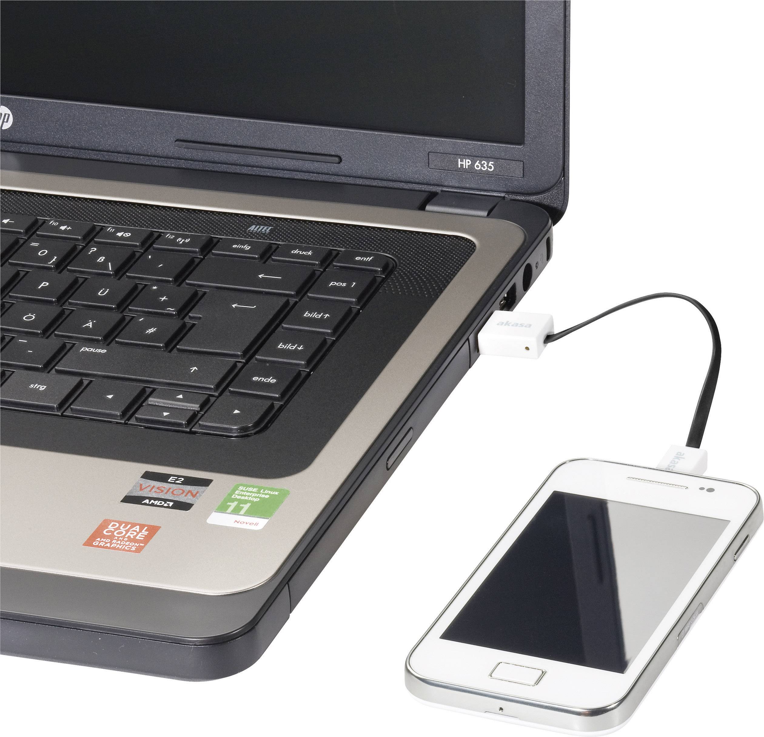 Un smartphone est connecté à un ordinateur portable via un câble USB. L'ordinateur portable affiche un clavier ouvert et un écran.