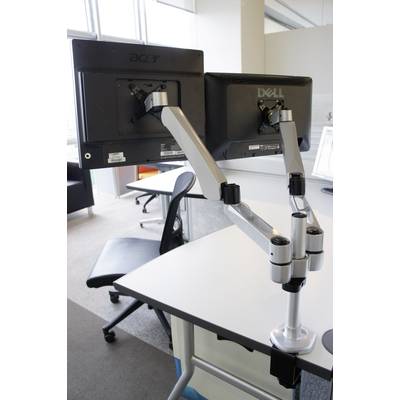 Un poste de travail moderne avec deux écrans sur des supports élégants et réglables, installés sur un bureau blanc dans un bureau.