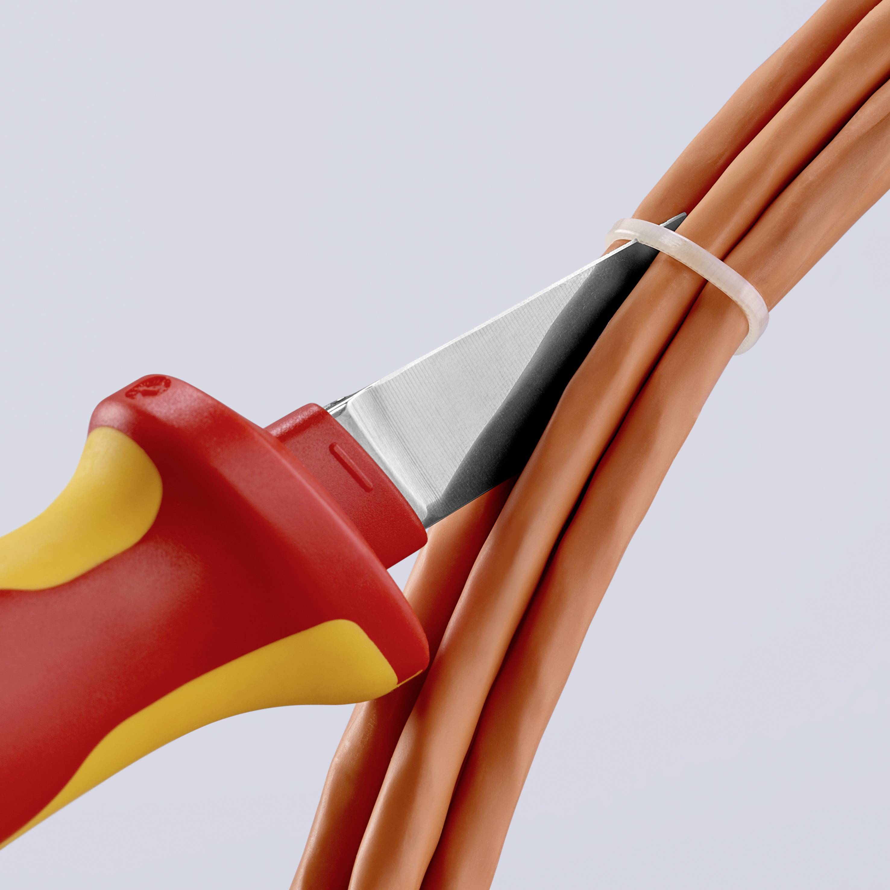 Nož reže narančaste kabele, pokazuje sigurnosnu primjenu u elektro području.