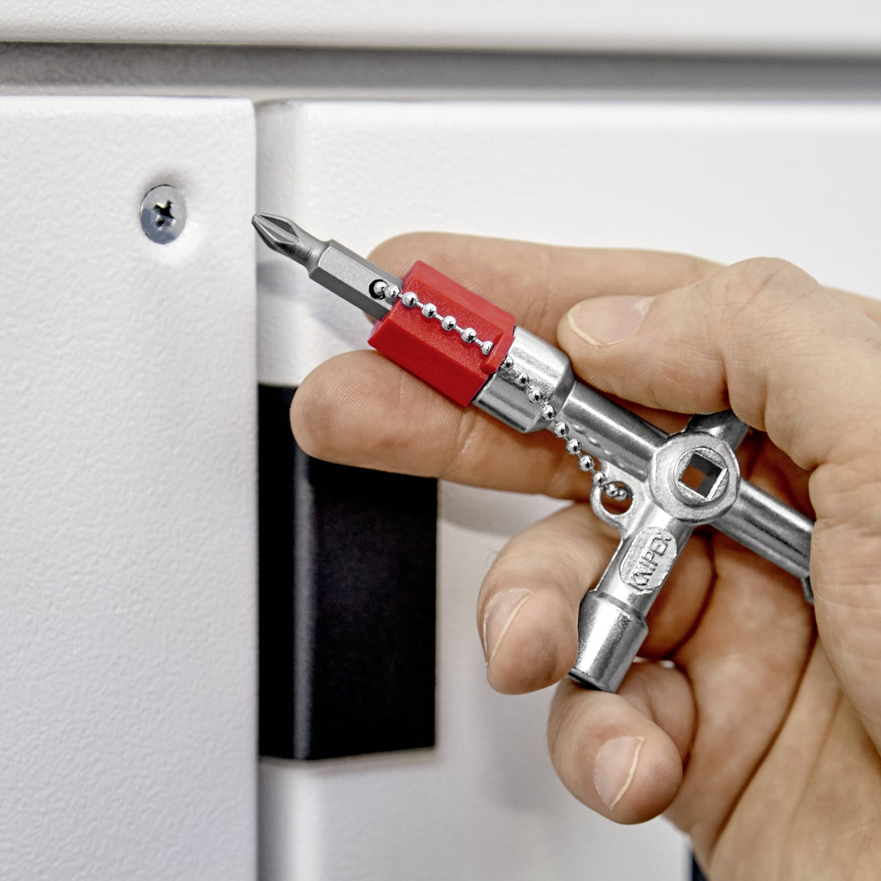 Jedna ruka drži univerzalni četverokutni ključ i otključava bravu bijele ormar.