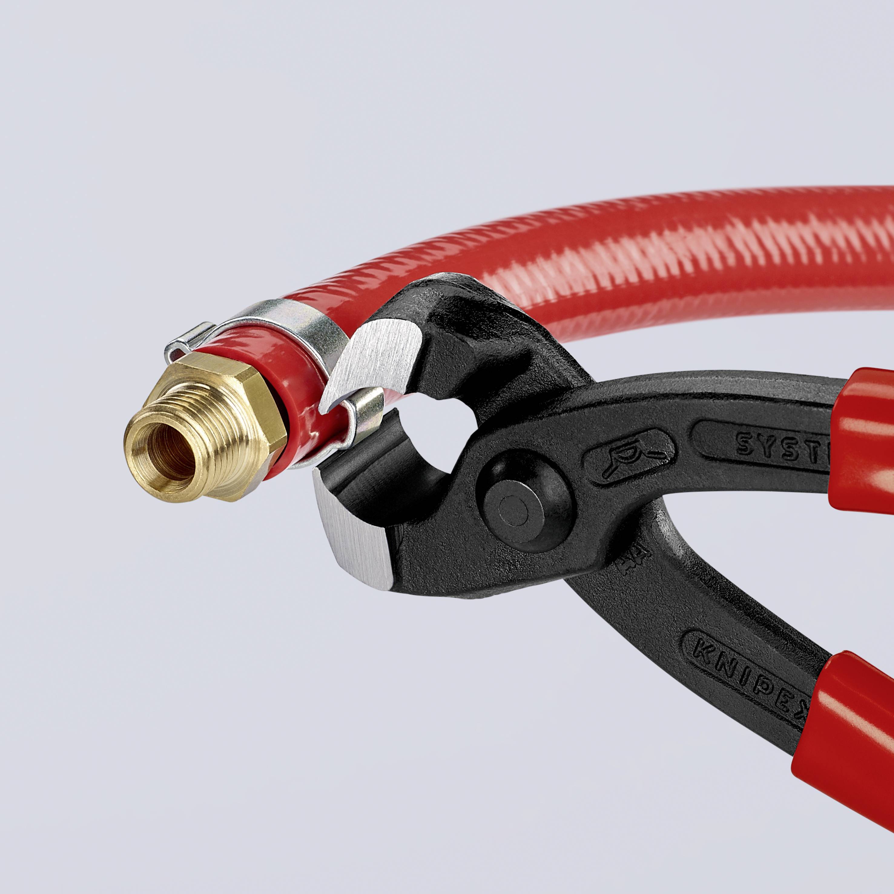 Crna kliješta odvajaju crvenu cijev s metalnim priključkom.