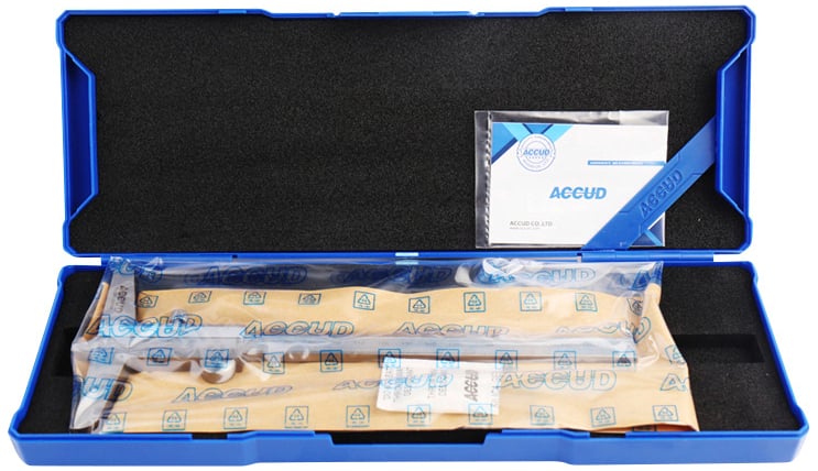 Plava futrola sadrži mjerni instrument, zaštićen plastičnom ambalažom. Priručnik za upotrebu leži pored njega.
