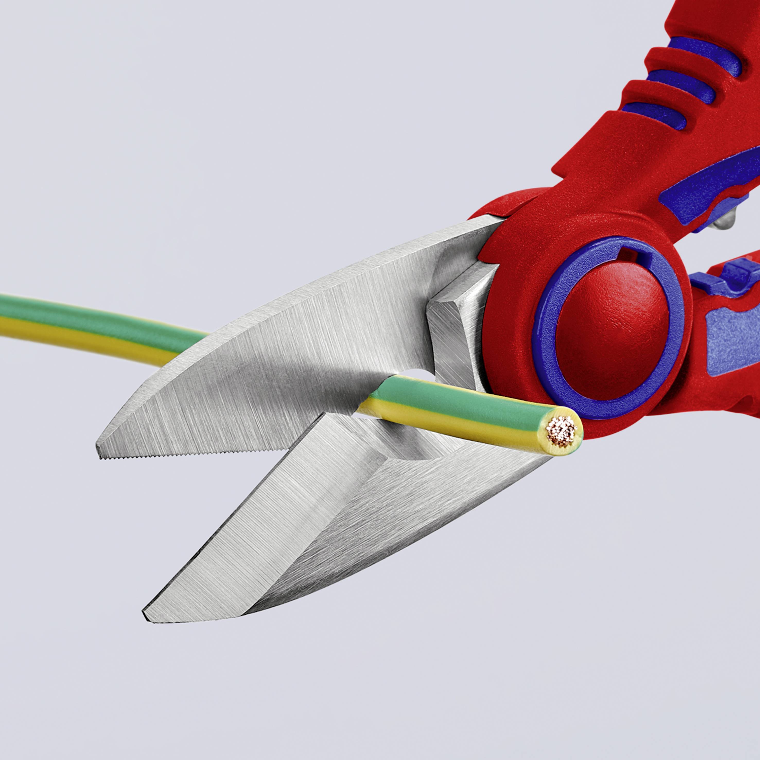 Crvena i plava kliješta prerezuju zeleni i žuti kabel, otkrivajući krajeve žica.