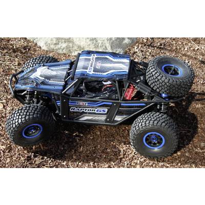 RC buggy s natpisom 'Raptor 6S' i 'Arrma' u plavoj i crnoj boji, stoji na tlu. Automobil ima velike, grubo profilirene gume.
