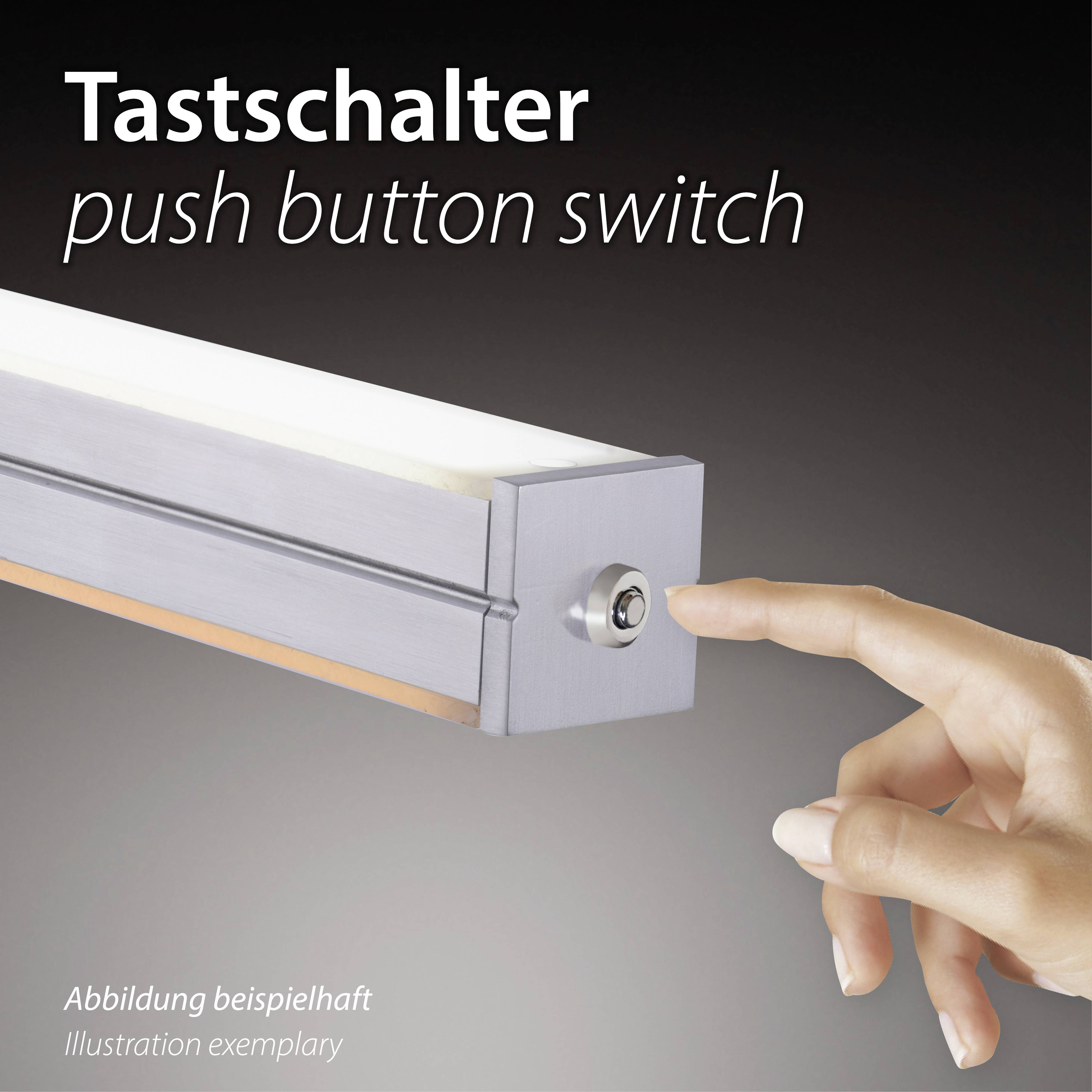 'Krupni plan ruke koja pritišće srebrni tipkasti prekidač na pravokutnoj lampi. Tekst: Tipkasti prekidač, push button switch.'